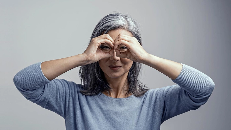 Una donna si tiene la mano sugli occhi come un binocolo.