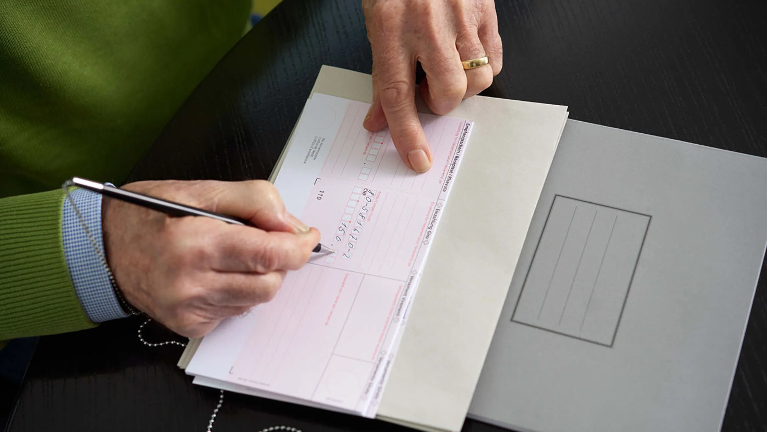 Einzahlungsschein wird ausgefüllt. 