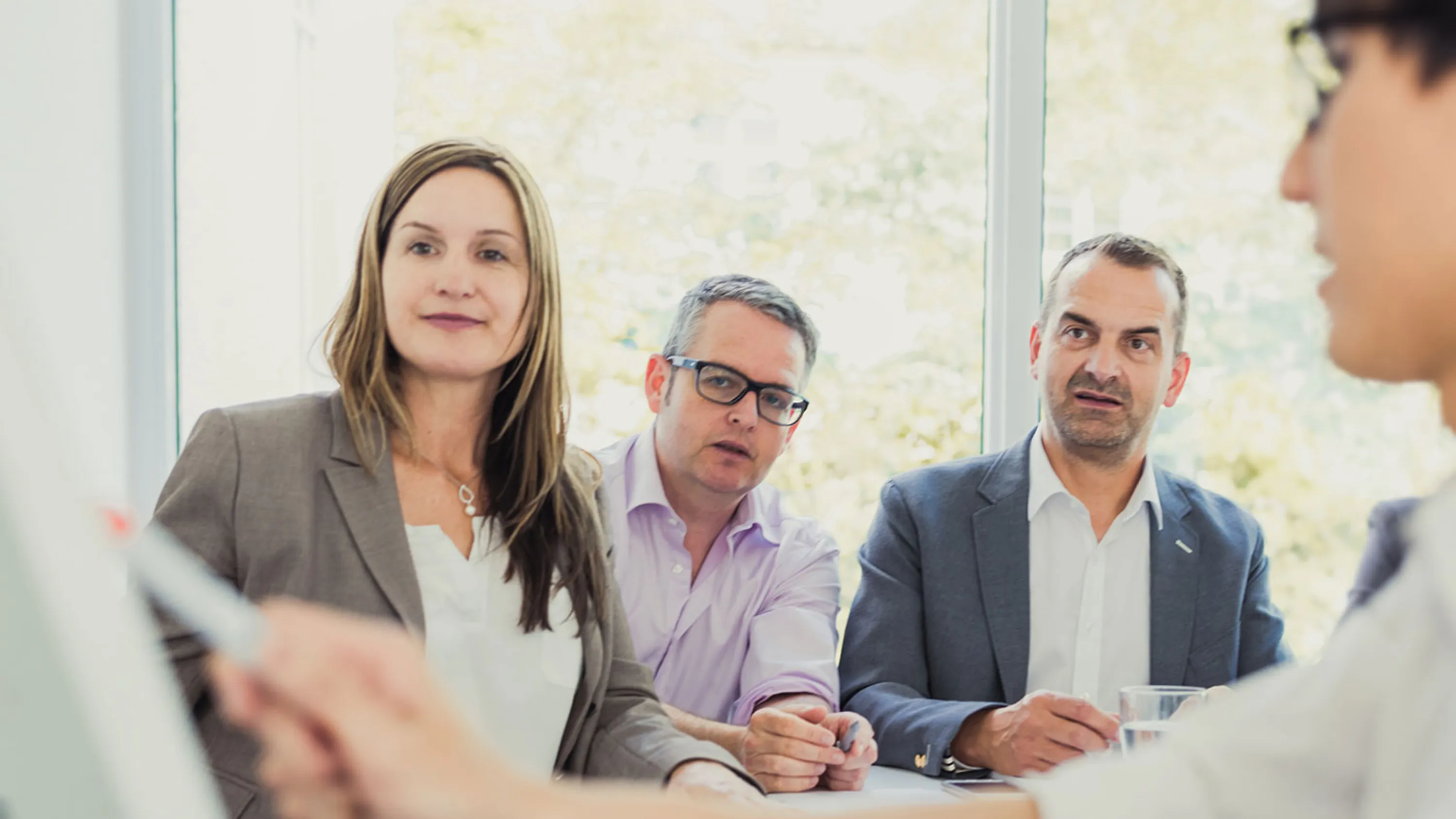 Gruppe von Menschen am Tisch bei Vortrag