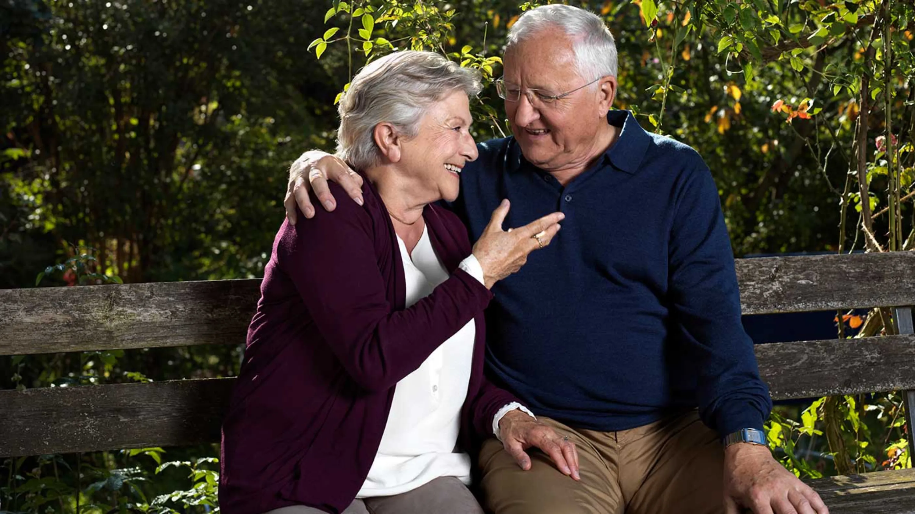 Glücklickes älteres Paar auf Parkbank