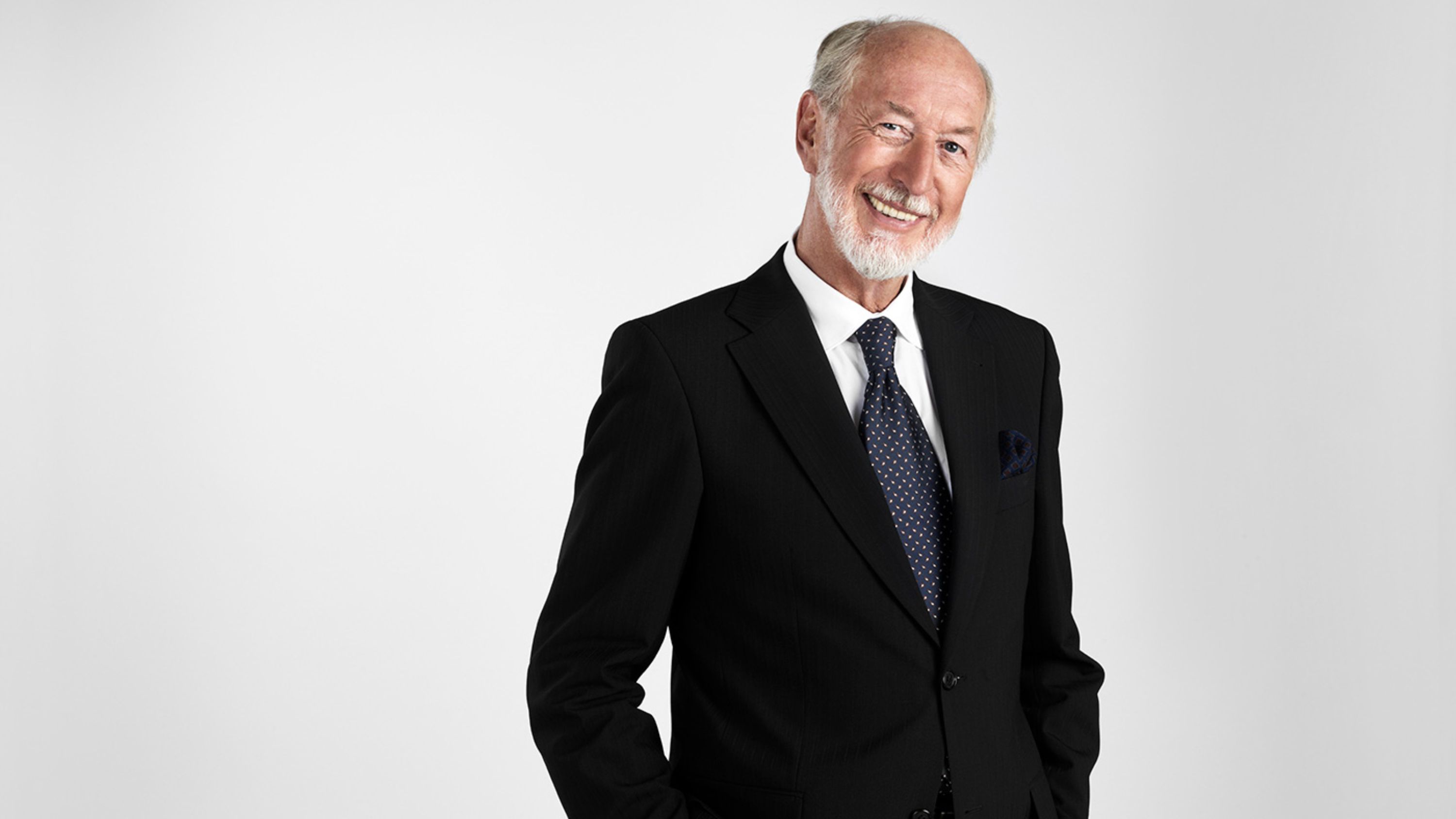 Senior in schwarzem Anzug lächelt freundlich