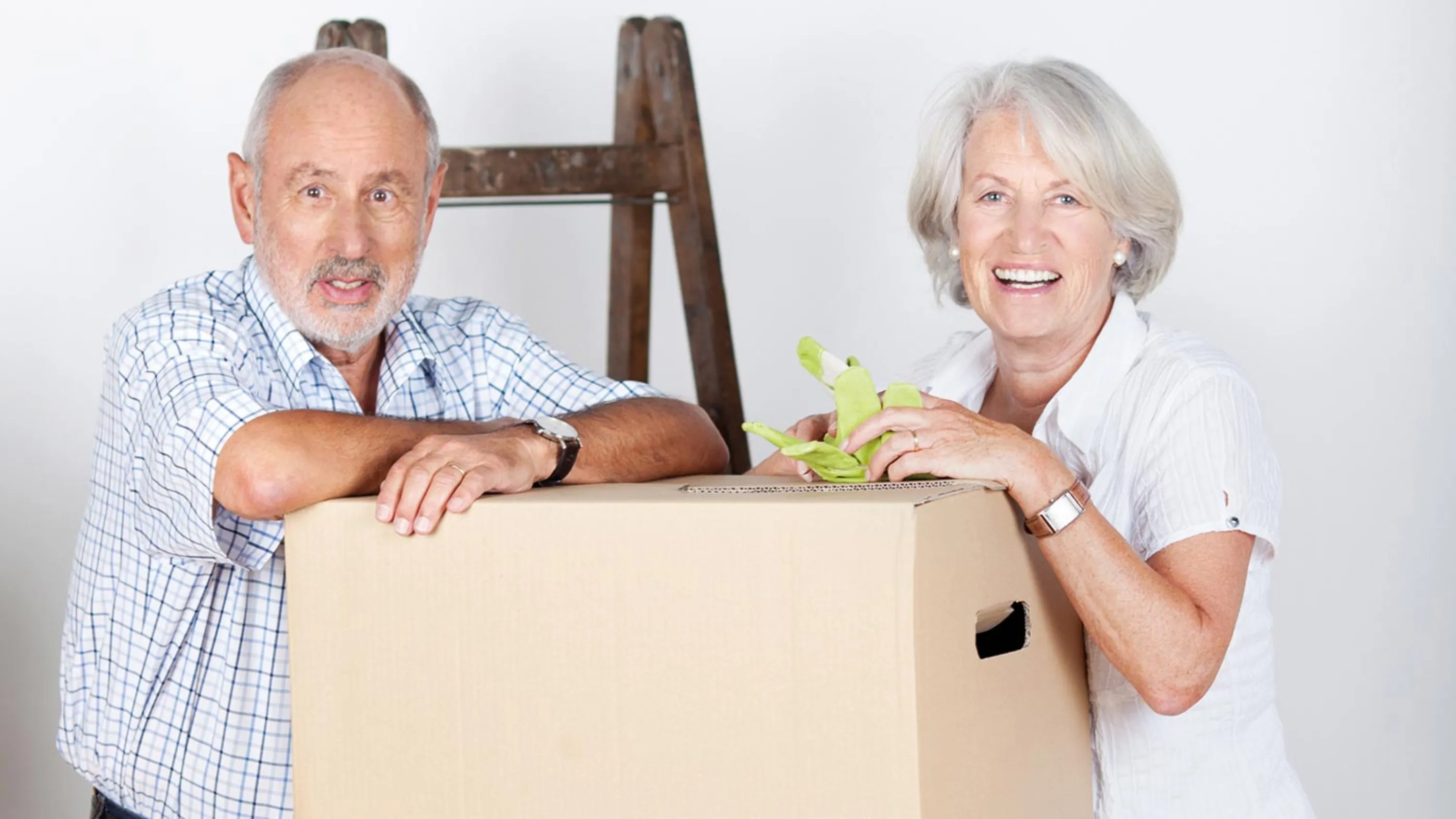 Seniorenpaar lehnt sich auf Umzugskisten