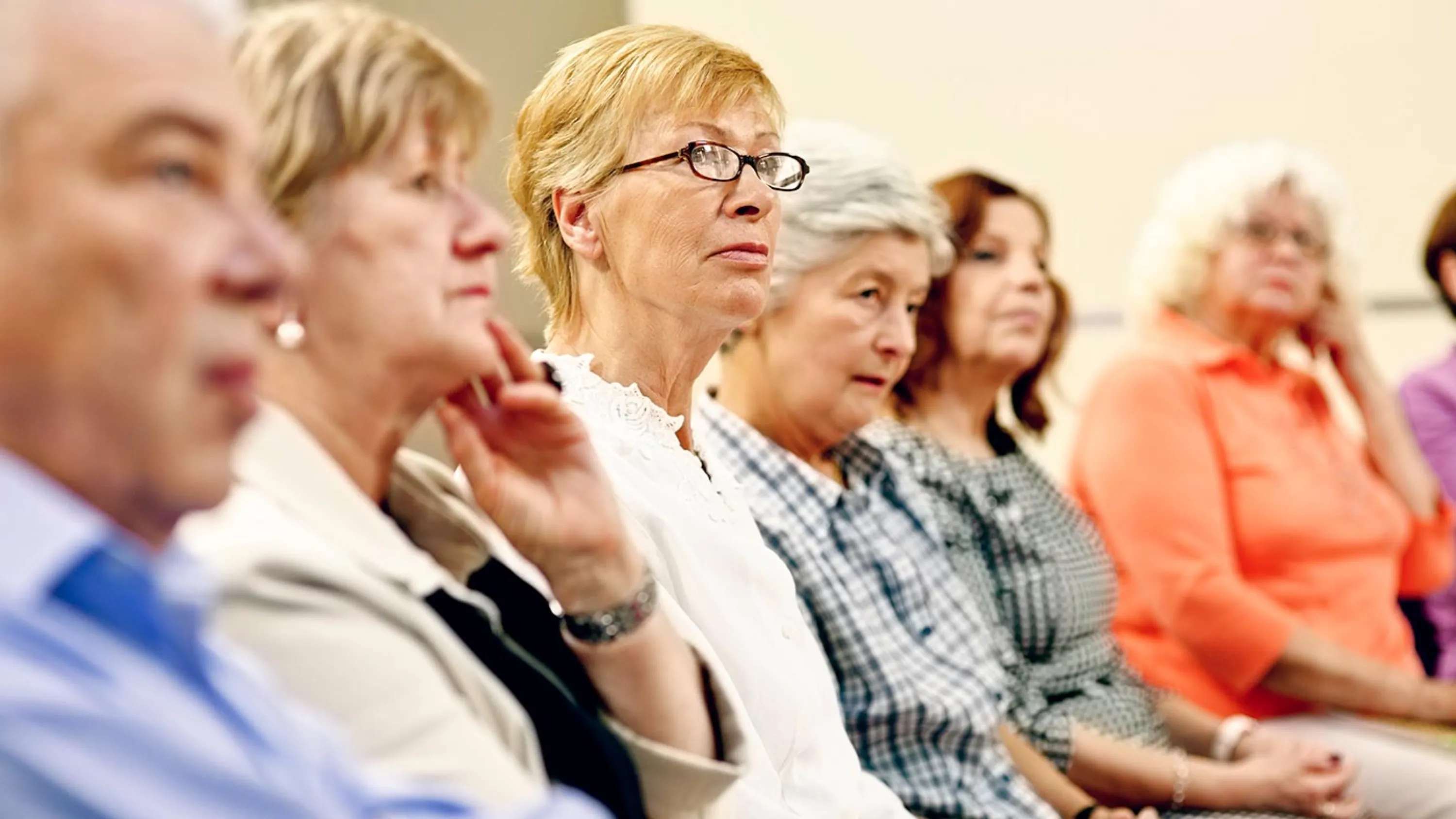 Teilnehmende in einem Seminar hören aufmerksam zu.