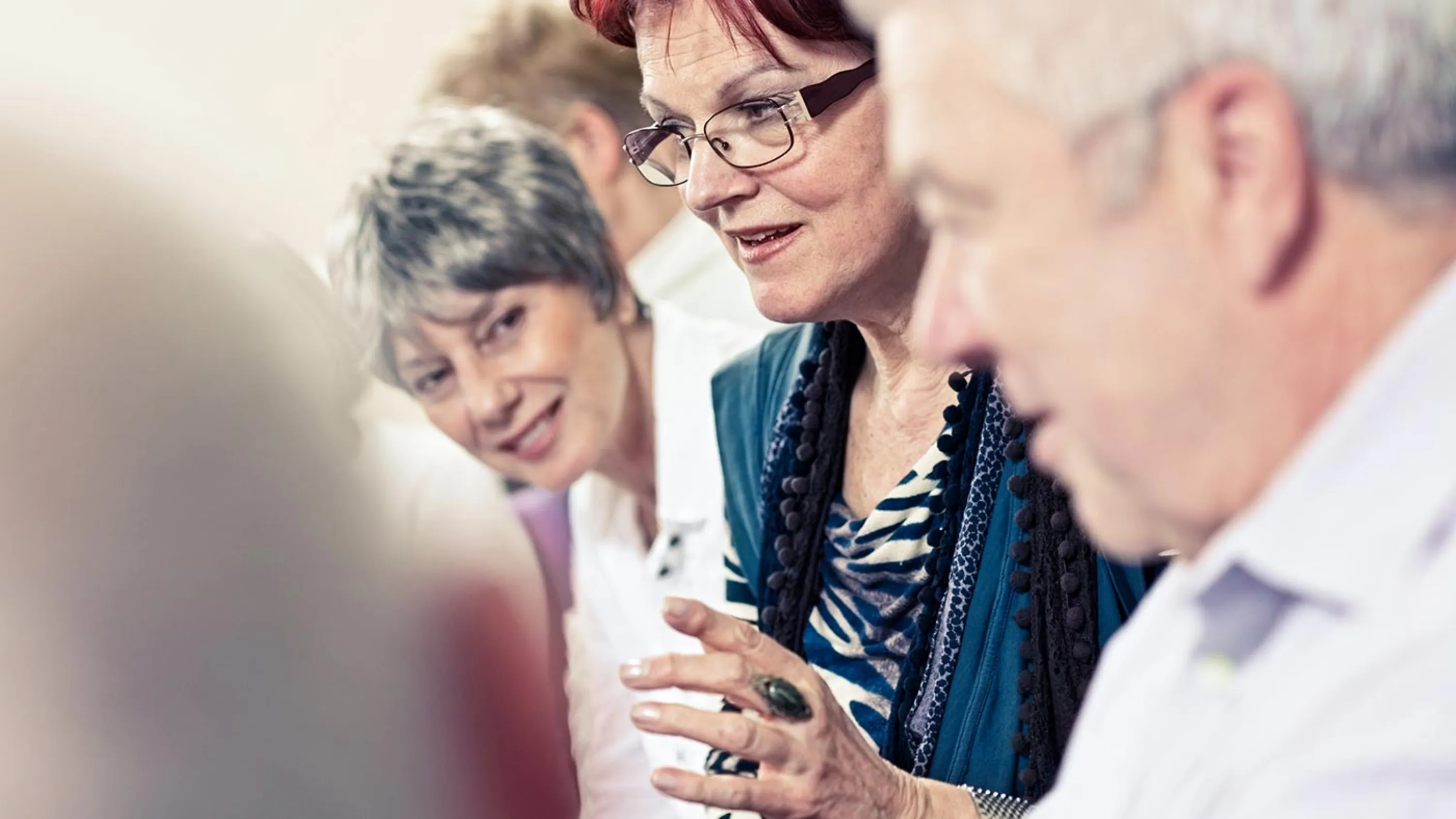 Teilnehmende eines Seminares sprechen miteinander.