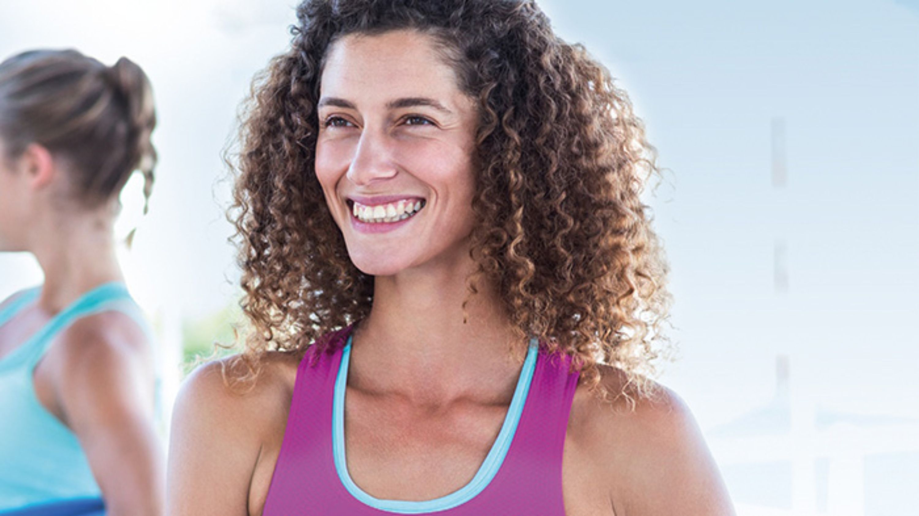 Eine junge Sportleiterin lacht in die Kamera.