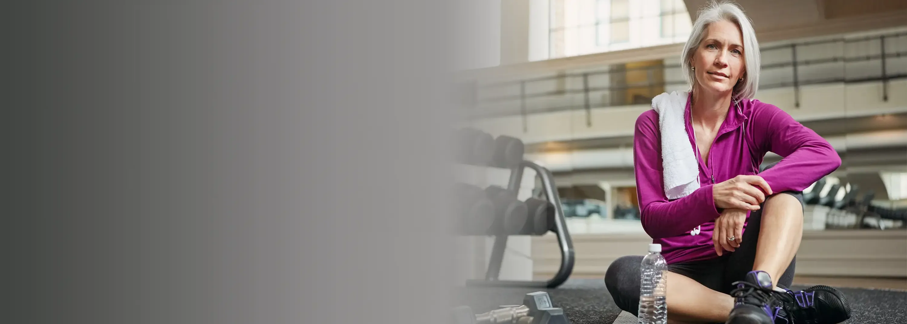 Eine Frau, die in einem Fitnessstudio sitzt.