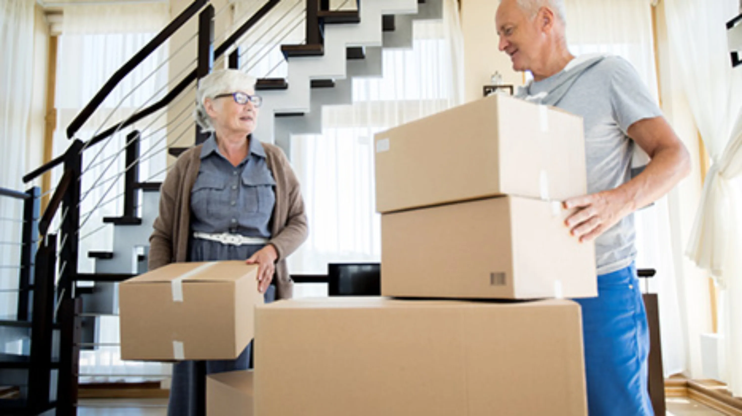 anziana con scatoloni e aiutante per il trasloco