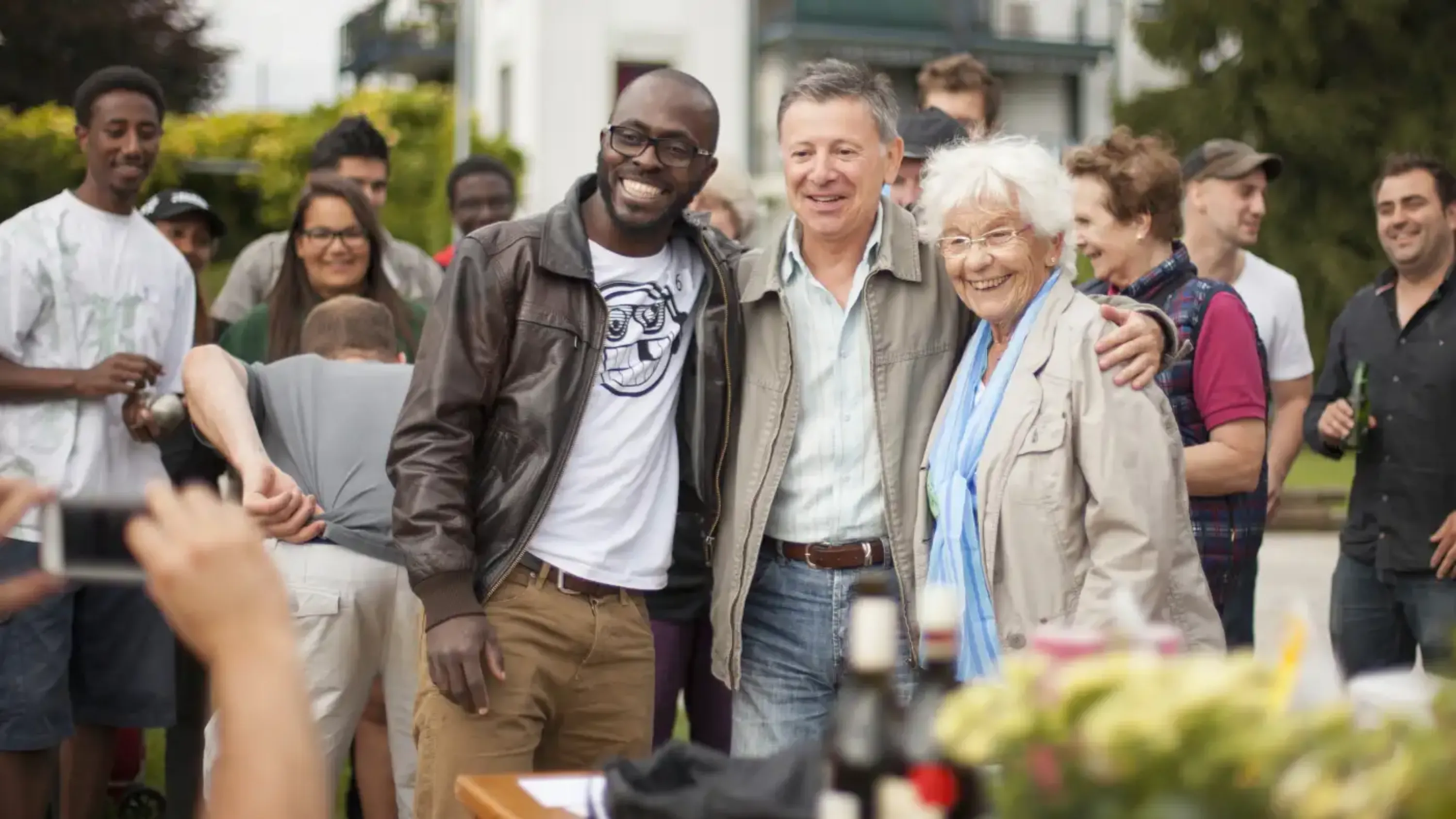 trois personnes qui posent pour une photo lors d'une fête en extérieur