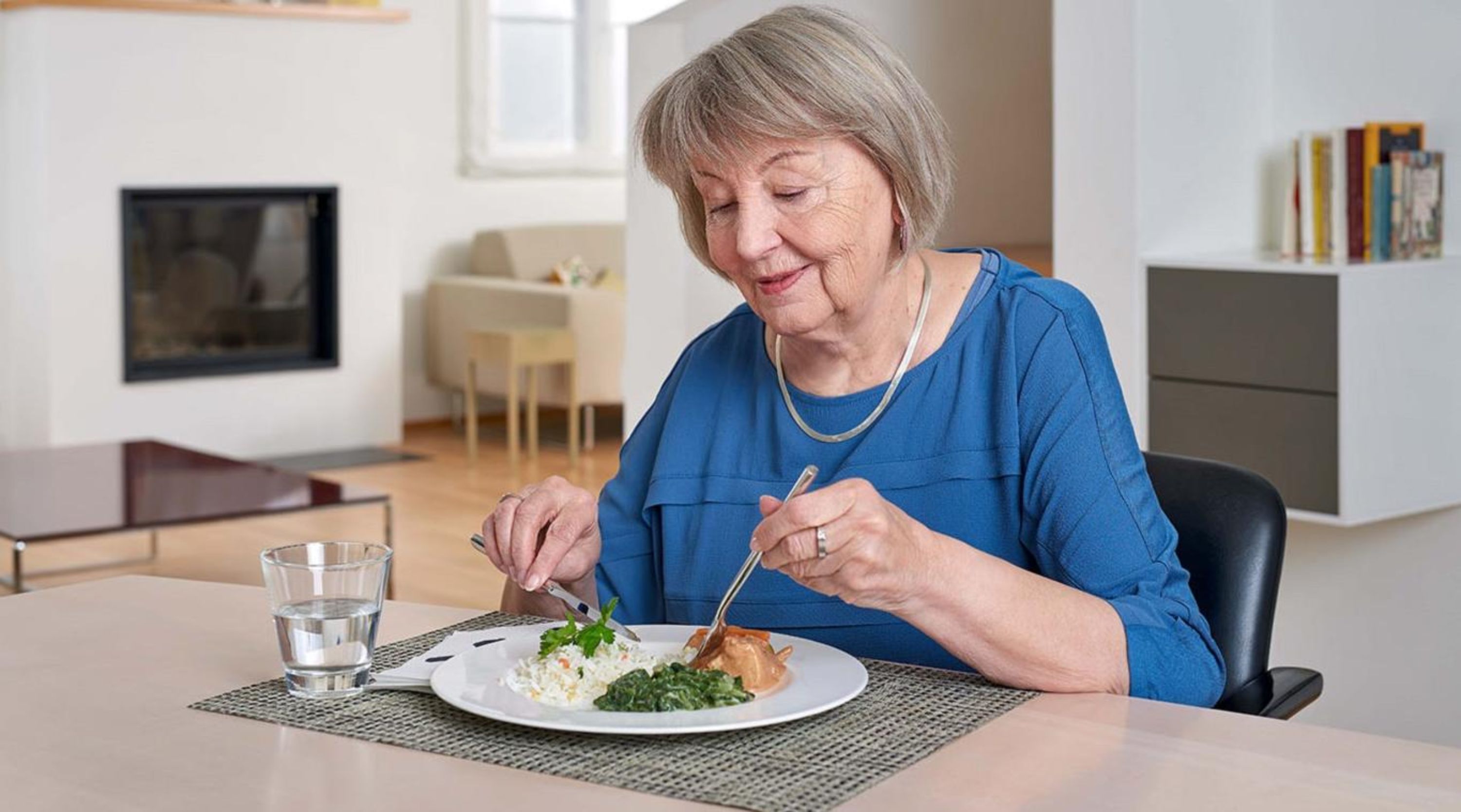 Une retraitée savoure son repas.