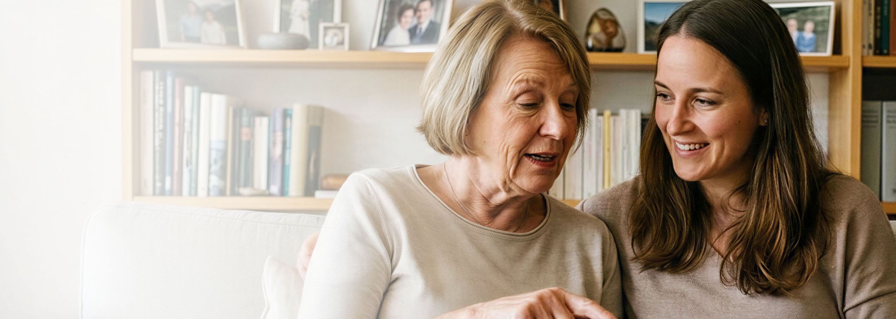 Zwei Frauen sitzen auf der Couch und besprechen etwas