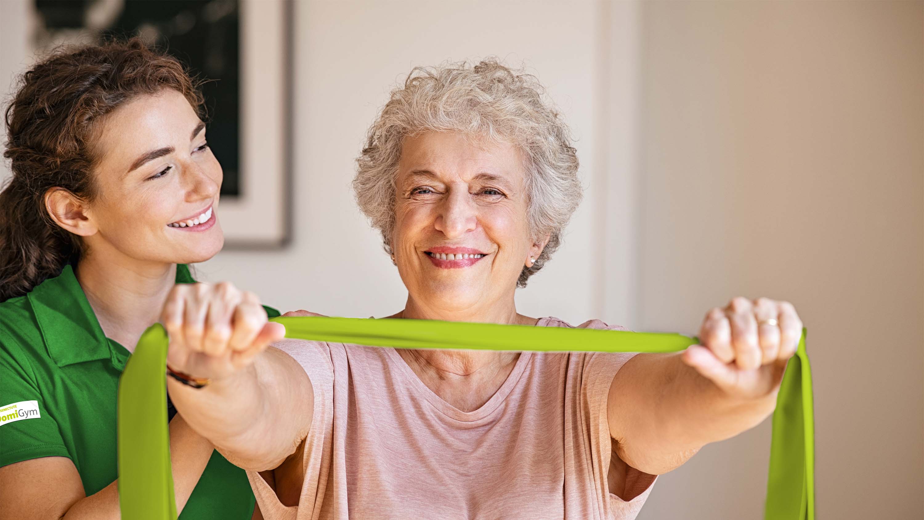 Eine Seniorin trainiert mit ihrer DomiGym-Trainerin in ihrem Zuhause.