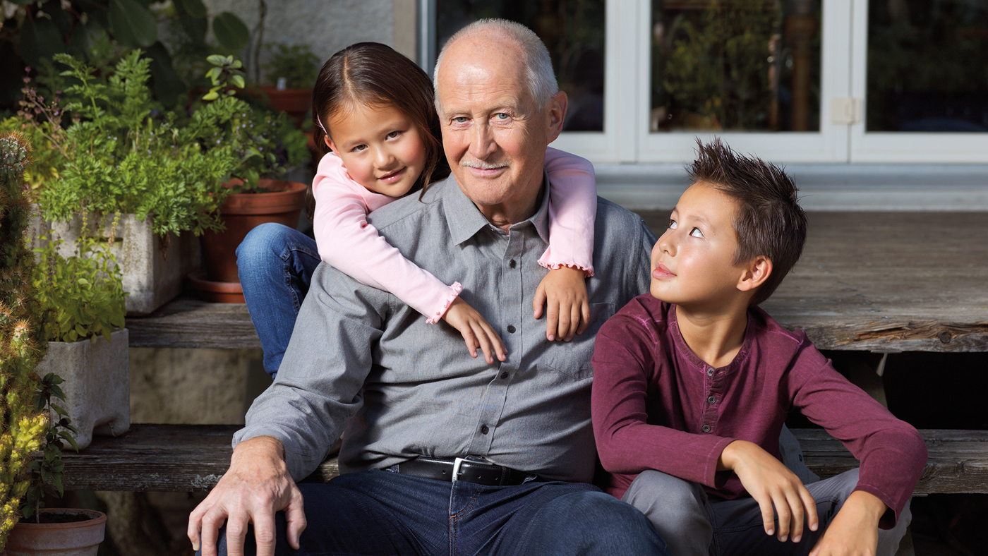 Senior avec ses petits–enfants dans le jardin .