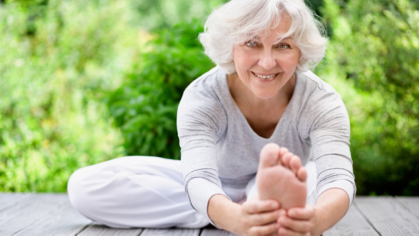 Une femme âgée étire sa jambe.