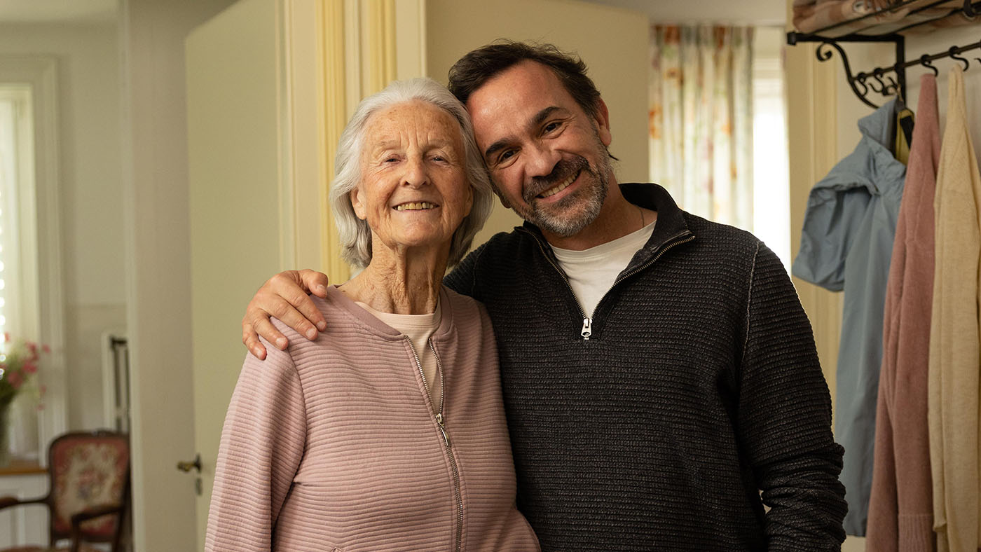 Eine Seniorin und ihr Sohn: Das Visual unserer Herbstsammlung 2022. 