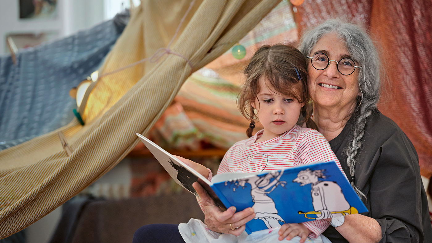 Una nonna sta leggendo un libro per bambini con sua nipote.