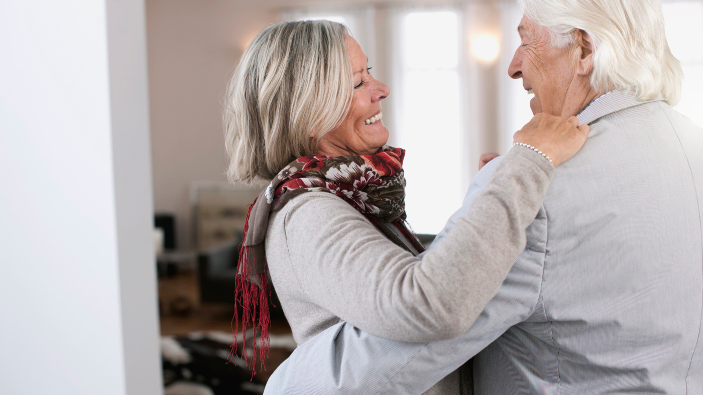 Un couple âgé s'embrasse en riant.