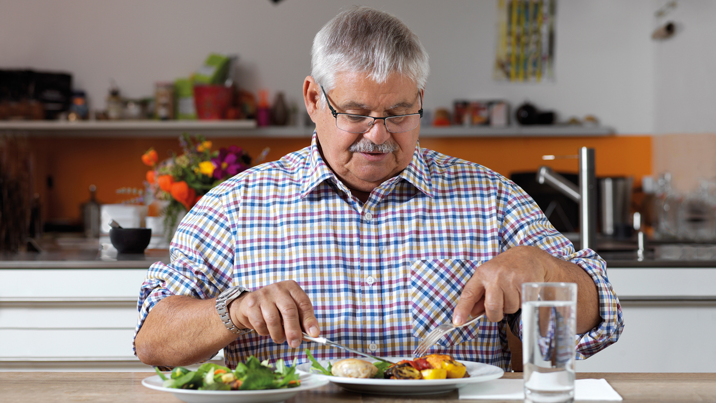 Sympathischer Senior beim Mittagessen