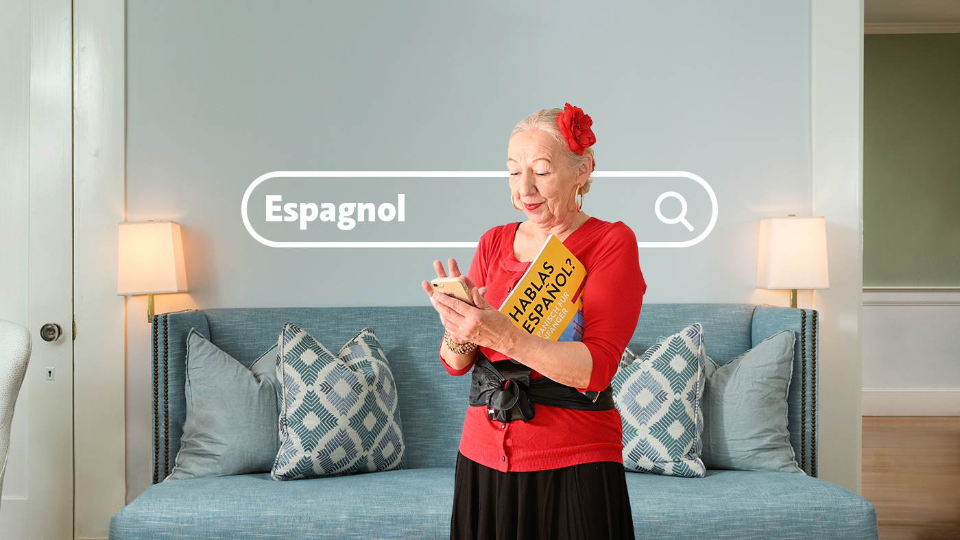 Une femme âgée avec un chemisier rouge est au téléphone.